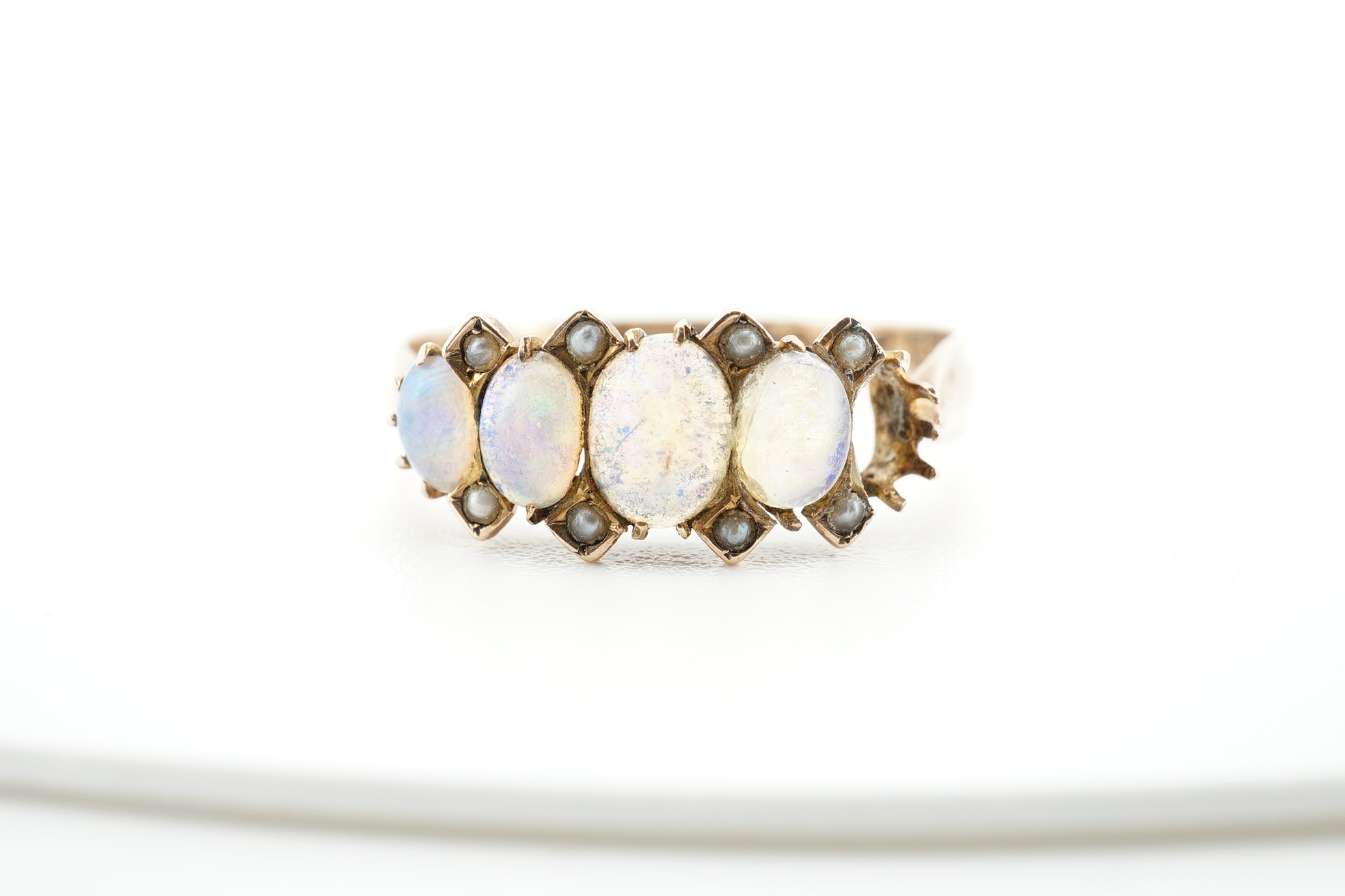 An early 20th century 9ct gold and opal cluster cluster set ring, size M, a 9ct and four(ex five) stone set opal half hoop ring and an 18ct and five stone diamond set half hoop ring. Condition - poor to fair